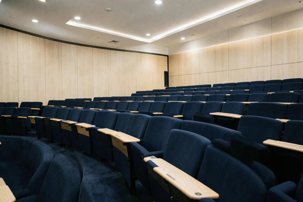 Amphithéâtre contemporain vide, fauteuils bleu nuit