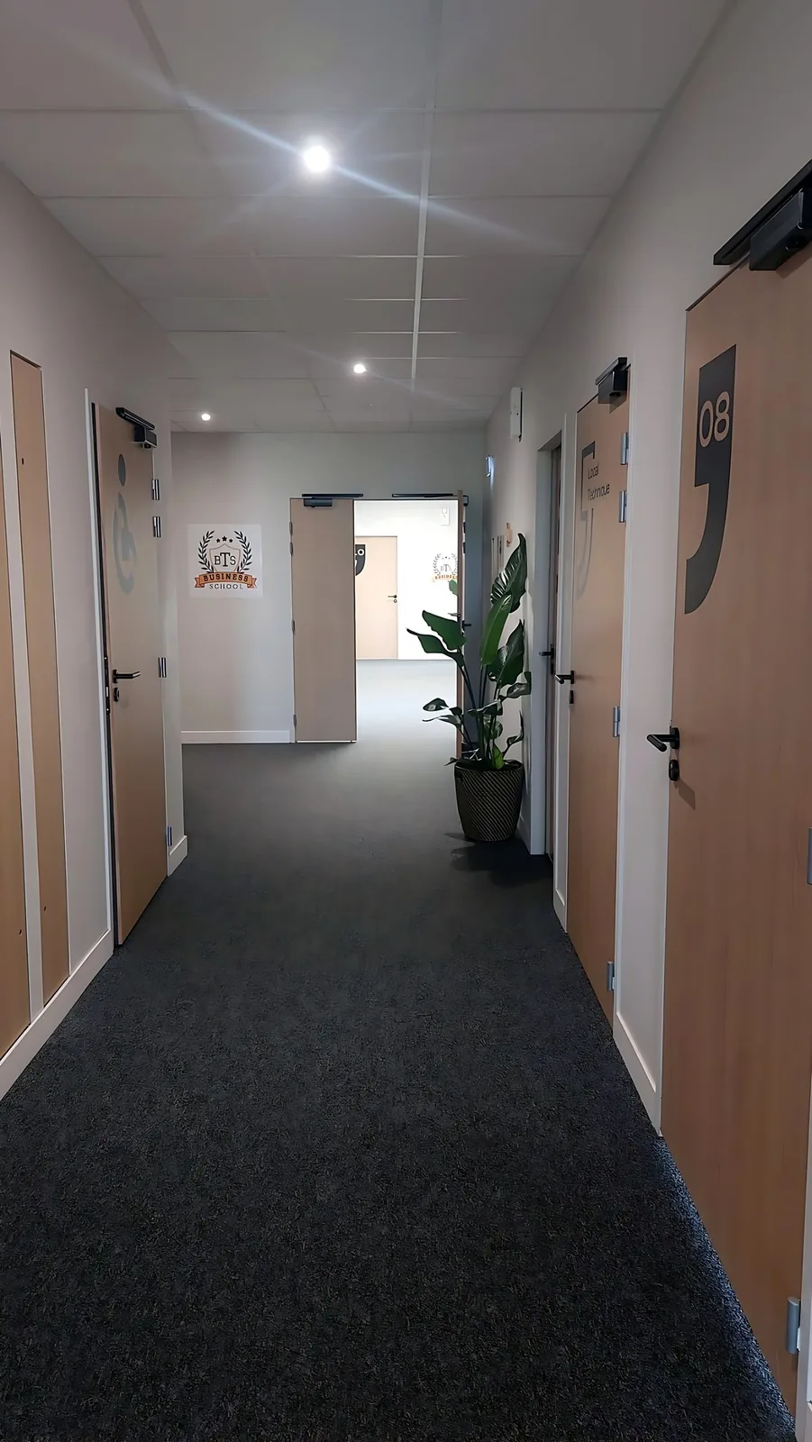 Le couloir des salles du campus, portes numérotées