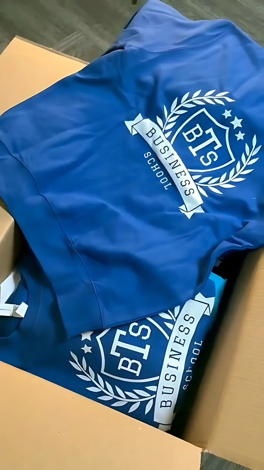 Sweats bleus aux couleurs de l’école, pliés et empilés