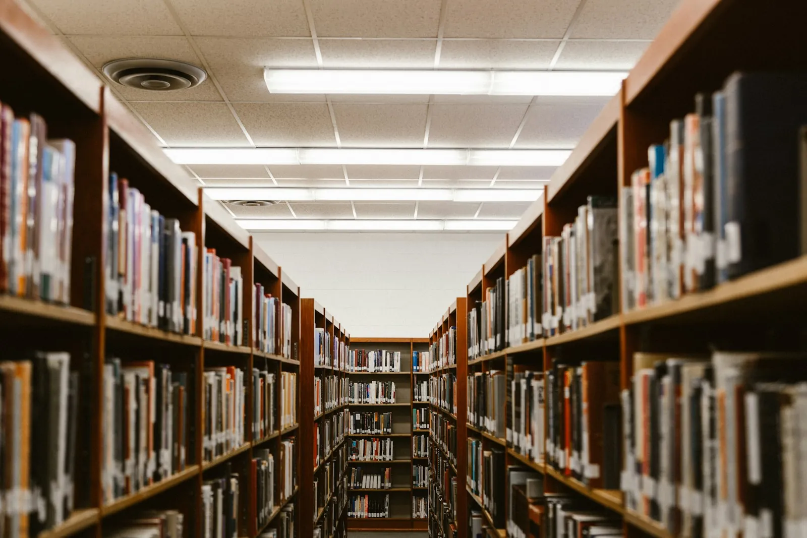 Allée centrale entre les rayonnages d’une bibliothèque